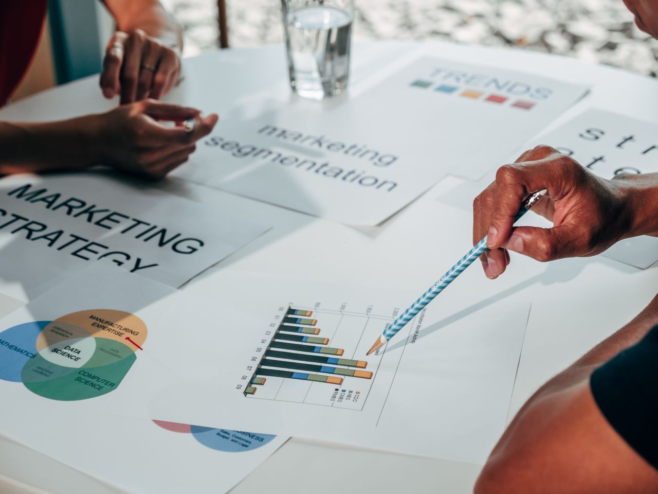 home-hero Team working on marketing strategy using data charts and papers in an office meeting.
