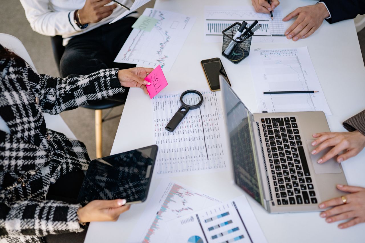 why-choose-us Business professionals collaborating on financial data analysis in a modern office setting.